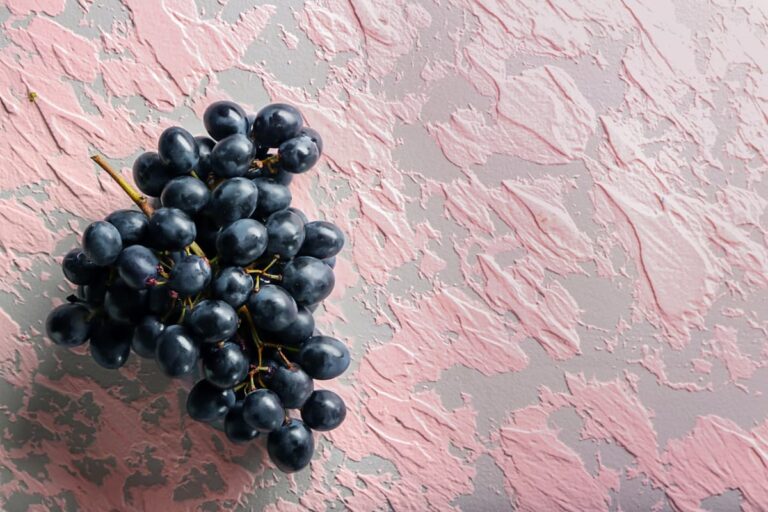 Ripe sweet grapes on color textured background